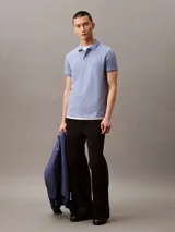 Chomba azul de poliéster con monograma de Calvin Klein, corte regular, mangas cortas y cuello polo con cartera de dos botones ocultos.