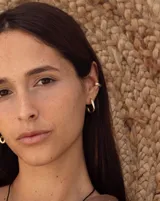 Aros de diseño minimalista con forma de argolla pequeña, realizados artesanalmente en bronce y alpaca con pernos de plata 925.