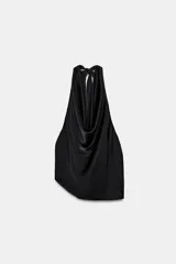 Top satinado negro con cuello halter y lazada en la nuca, escote drapeado y bajo asimétrico.