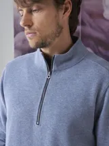 Fleece de algodón color azul, con cuello alto y cierre frontal parcial. Diseño de manga larga con puños y ruedo acanalados.