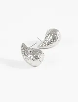 Par de caravanas plateadas con forma de gota irregular y textura martillada.