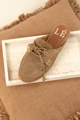 Mules de gamuza color tostado con diseño de zapato náutico, con cordones frontales y plantilla con logo estampado.