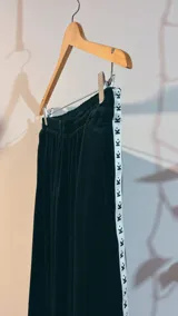 Pantalón de jogging negro de plush, con elástico en la cintura, bolsillos laterales y cinta con logo a lo largo de la pierna.