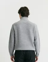 Remera de punto inglés con cuello alto y medio cierre metálico. Presenta mangas largas y puños en punto canalé.