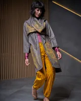 Túnica gris con capucha, confeccionada en gabardina de lana estampada artesanalmente con diseño abstracto en tonos ocre. Presenta dos piezas a modo de bufandas que se anudan en la parte delantera, bolsillos laterales y capucha amplia.