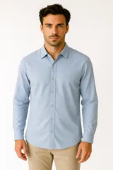 Camisa celeste de manga larga con cuello clásico y cierre frontal con botones.