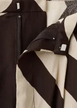 Pantalón largo de tiro medio confeccionado en viscosa fluida, con diseño recto y estampado de cebra en tonos marrón y beige. Cuenta con dos bolsillos laterales y cierre de botón.