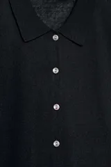 Chaqueta de punto celeste, de manga corta, con cuello solapa y cierre frontal con botones.
