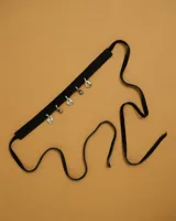 Gargantilla tipo choker de gamuza con dijes colgantes artesanales de metal y perlas naturales. Cuenta con tiras largas para atar y ajustar en la parte posterior.