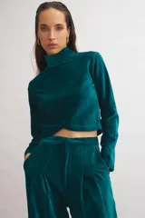 Top de terciopelo azul marino, de corte cropped, con cuello alto y espalda descubierta.