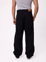 Jean de corte slouchy en color negro, confeccionado en algodón, con diseño de tiro medio y ajuste holgado en las piernas.