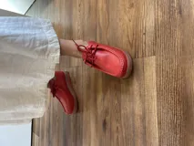 Zapato acordonado de cuero negro con suela de goma.