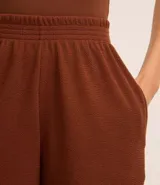 Short femenino de corte holgado confeccionado en tejido rib con textura acanalada. Cuenta con cintura elástica y bolsillos laterales.