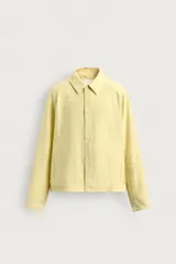 Sobrecamisa relaxed fit de color amarillo claro, confeccionada en tejido con mezcla de lyocell. Presenta cuello solapa, mangas largas raglán con puños abotonados, bolsillos de vivo en la cadera y cierre frontal con botonadura.