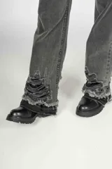Pantalón de jean gris oscuro de corte wide leg con roturas y desgaste en el ruedo y las piernas.