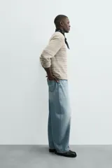 Camiseta de manga larga con cuello redondo y ajuste relajado, confeccionada en tejido de punto con estructura abierta y patrón de rayas horizontales.