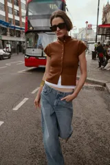 Top de tejido de punto color marrón óxido, manga corta y cuello mao con cierre frontal de botones.