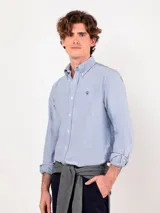 Camisa Oxford de manga larga en color celeste, con cuello con botones y pequeño logo bordado en el pecho.