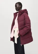 Campera puffer color bordó con capucha, cierre frontal con cremallera y diseño acolchado con costuras horizontales.