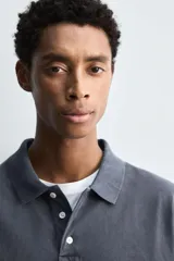 Polo de manga corta con cuello solapa y cierre frontal de tres botones. Presenta un diseño de corte relajado con acabado de efecto lavado.