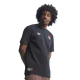 Remera de algodón negra con cuello redondo y mangas cortas. Presenta el logo del trébol de Adidas bordado en blanco en el lado derecho del pecho y un parche circular con los colores rasta en el lado izquierdo. Incluye un parche rectangular en la parte inferior con la inscripción Football is Freedom y una imagen de Bob Marley.