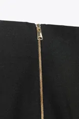 Pantalón de vestir color crudo, de tiro alto y pierna acampanada.