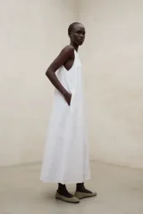 Vestido largo blanco de lino ligero, sin mangas, con cuello redondo y silueta fluida.