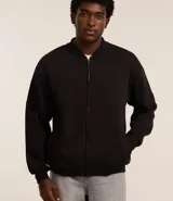 Campera bomber negra de algodón y poliéster, con cuello en V, cierre frontal con cremallera, bolsillos laterales, mangas largas con puños ajustados y bajo con ajuste.