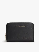 Billetera compacta Tommy Hilfiger de color negro, con acabado texturizado de líneas horizontales y cierre de cremallera metálica dorada. Cuenta con el logo de la marca en letras metálicas doradas en la parte frontal.