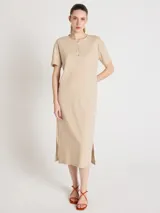 Vestido midi color beige, de corte recto y silueta relajada, con escote redondo, mangas cortas, cierre parcial de botones en el frente y aberturas laterales en el bajo.