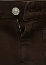 Pantalón tipo jeans de corte flare y diseño crop, color marrón. Presenta tiro medio, cierre frontal con cremallera y botón, trabillas para cinturón y dos bolsillos de parche en la parte delantera. El ruedo tiene un acabado deshilachado.