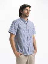 Camisa de hombre de manga corta con estampado a cuadros en tonos blanco, verde y marrón. Tiene cuello abotonado y bolsillo en el pecho.