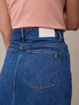 Falda midi de jean azul claro con corte en el centro del frente.