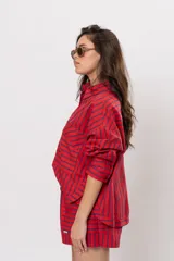 Camisa roja de manga larga con rayas verticales azul marino, bolsillos frontales con solapa y cierre de botones.