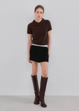 Minifalda negra de corte cruzado con diseño tipo short pollera, confeccionada en mezcla de poliéster, viscosa y elastano.