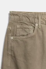 Jeans de tiro medio con diseño baggy barrel, cinco bolsillos y costuras laterales torcidas. Presenta cierre frontal con cremallera y botón metálico.