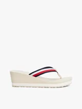 Sandalias tipo ojota con plataforma de cuña alta, color beige claro. Las tiras son de tejido trenzado con las franjas distintivas de Tommy Hilfiger (azul marino, blanco y rojo).