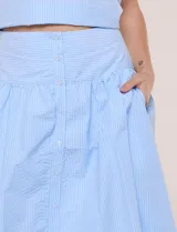 Falda midi abotonada de textura gofrada y diseño a rayas. Presenta cintura ancha entallada, abotonadura frontal completa, corte con frunce para mayor amplitud y bolsillos laterales funcionales. Cuenta con forro interno.