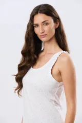 Musculosa de algodón color beige con delicado estampado floreado, escote redondo y pequeños volados en las sisas.