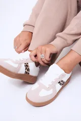 Championes urbanos de diseño clásico, combinando paneles en color blanco y beige con detalles laterales en estampado animal print de leopardo. Presentan suela de goma en tono caramelo y cierre mediante cordones blancos.