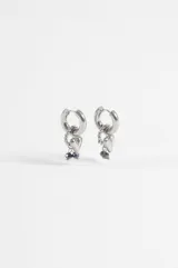 Aros argolla de acero quirúrgico plateado con dijes colgantes en forma de corazón y pequeñas cuentas de cristal oscuro.
