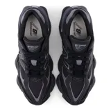 Championes New Balance modelo 9060, color negro con detalles en gris oscuro. Presentan una silueta chunky con superposiciones de gamuza y malla, y una entresuela sobredimensionada con tecnología ABZORB.
