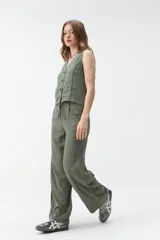 Pantalón de corte ancho y tiro medio, color verde militar, con cintura elástica ajustable mediante cordón y bolsillos laterales.