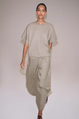Pantalón ZARA Woman Collection de lino 100%, de tiro medio y color gris claro, con cintura elástica ajustable mediante cordones y bajo redondeado con aberturas laterales.