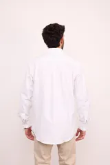 Camisa blanca de vestir, corte clásico, con cuello abotonado y bolsillo en el pecho.