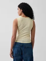 Musculosa marrón oscura de tejido pointelle, con cuello redondo y ribetes con terminación en ondas.