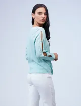 Blusa tejida color celeste con lurex, de manga larga con aberturas y apliques de brillo. Ruedo anudado.