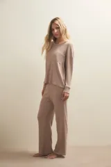 Conjunto de pijama compuesto por una remera de manga larga con bolsillo frontal y un pantalón de corte recto, ambos confeccionados en tejido de punto acanalado.