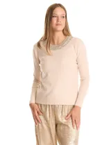 Buzo de tejido fino color beige, con cuello redondo decorado con apliques de brillos y mangas largas.