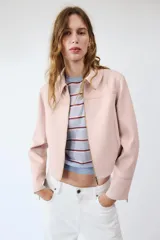 Chaqueta rosa de cuello solapa y manga larga, con cierre frontal y detalles de cremallera metálica.